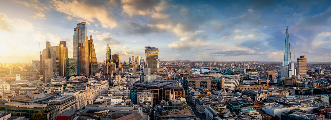 Panoramic view of London skyline at sunset featuring The Shard and modern skyscrapers in the financial district