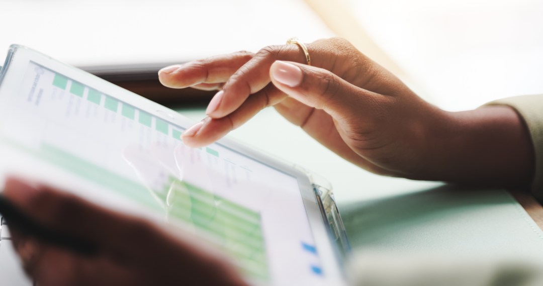 Professional reviewing catastrophe modeling data and risk analytics on a tablet.